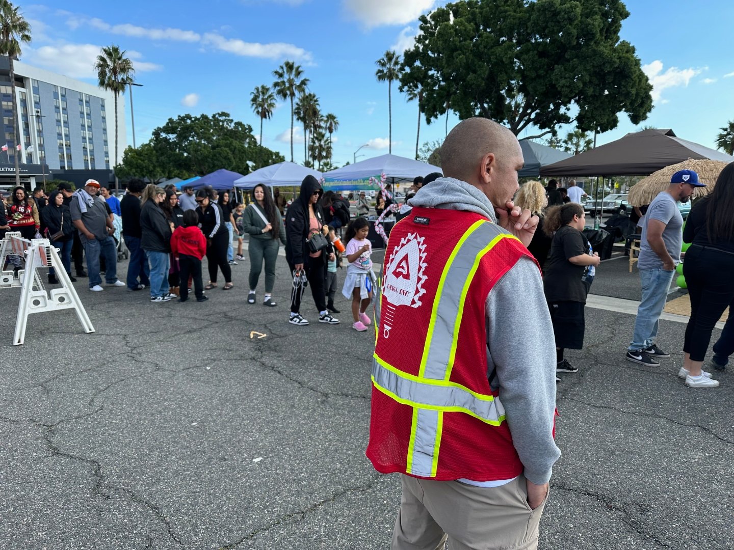 A Kūpay safety ambassador in a reflective vest covering a community event